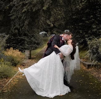 a bride and groom kissing on a path