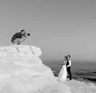 fotografo in azione al mare con due sposi