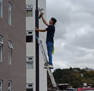 técnico realizando mantenimiento a cámaras de seguridad de un condominio