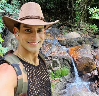 Travel writer Rick Silvia in the jungle in Thailand smiling in front of a small waterfall