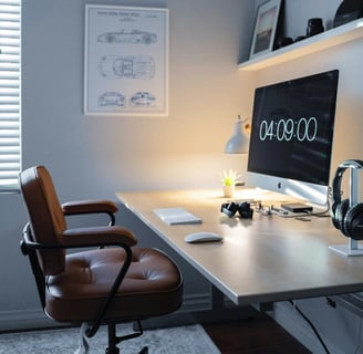 a desk with a computer monitor and a desk with a clock