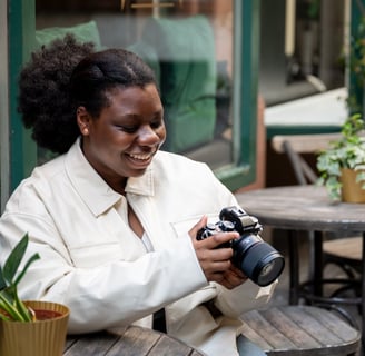 a black woman smiling in white jacket looking at outdoor photography photos