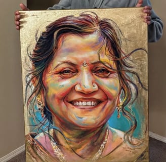 Artist S.K. Gusani holding a memorial painting of a smiling woman, gold leaf, portrait art