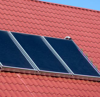 a house with a red roof and a solar paneled roof