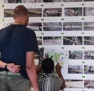 a man and a woman are standing in front of a wall with pictures of fallen trees