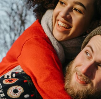 a man and woman laughing in the snow