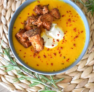 a bowl of soup with croutons and cream