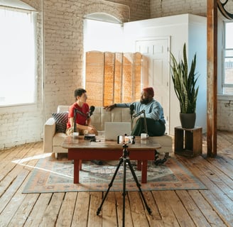 Video podcaster and guest sitting on a sofa