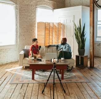 Video podcasters sitting on a couch in a loft