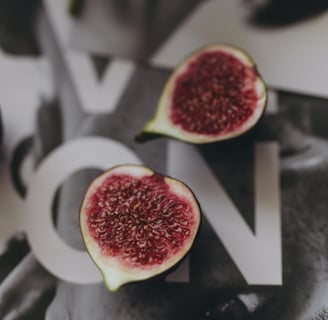Close-up of ripe figs placed on a reflective fashion magazine spread