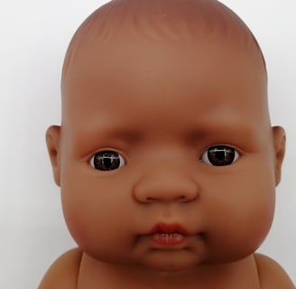 a Miniland baby doll with brown eyes