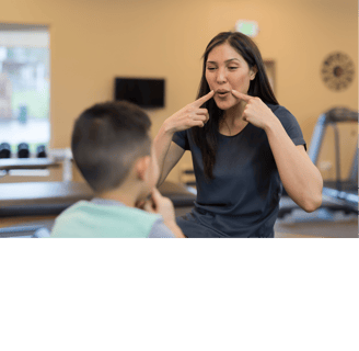 Fonoaudiologa ensinando autista. a woman in a gym room with a man brushing his teeth