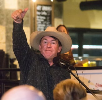 a man in a cowboy hat and a microphone