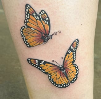 a butterfly tattoo on the leg of a woman's leg