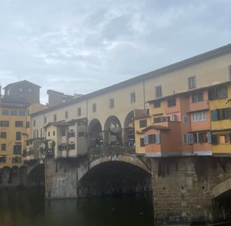 the ponte vecchio in Florence, Italy with medieval towers in the background