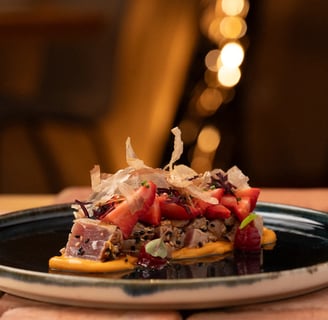 Fotografía profesional de un tataki de atún con ckatsobushi, fresas y una cama de una salsa deliciosa, .
