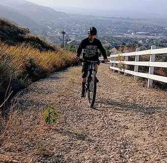 Mountain biker climbing a loose gravel trail, staying seated for traction and control