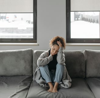 una mujer cansada en un sofá gris