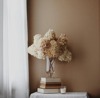Fleurs séchées sur des livres, symbolisant un espace calme de ressources énergétiques et de clarté s