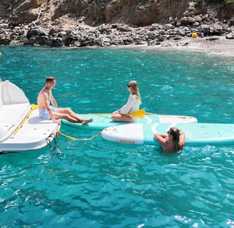  Group of friends relaxing on a boat with crystal-clear waters in the background    Pregu