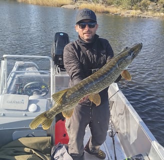 en fiskare är på en fiskebåt, båten är en "linder 460". han fångade en gädda i Sverige.