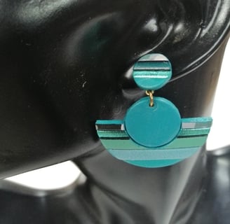 a woman's earring with a blue and green earrings