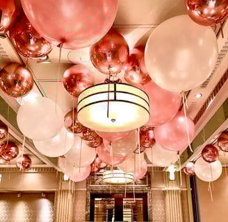 Festive balloon ceiling decor with pastel and metallic balloons for a 1st birthday celebration.