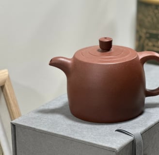 A brown Yixing teapot placed on a gray gift box