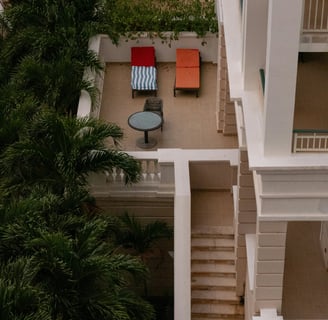 a balcony with a table and chairs in the middle of the room