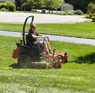 a man riding on a lawn mower with a lawn mower