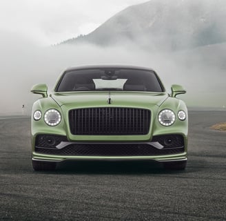 a green bentley flying spur in the swiss mountains
