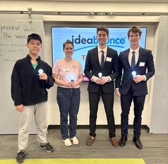 a group of four people holding lightbulbs in front of an ideabounce sign