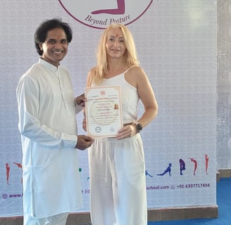 Eva receiving her yoga teacher certificate after completing training