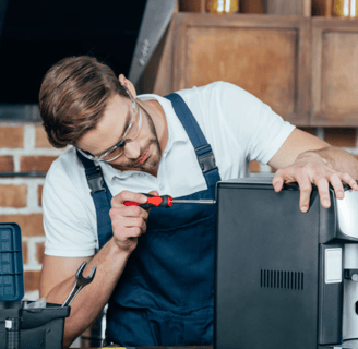 a man in a blue apron and glasses is working on a computer