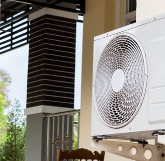 a white air conditioner sitting on a chair