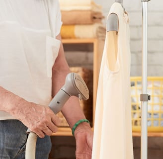 a woman in a white shirt is holding a vacuum