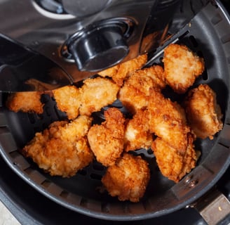 a fryer with chicken nuggling in it