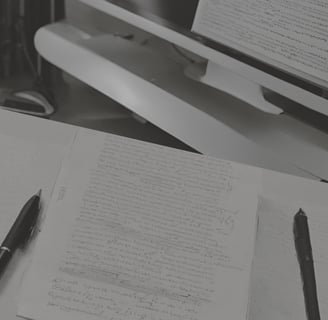 Un ordinateur, un manuscrit et un stylo