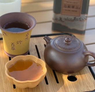teacup and teapot placed on a wooden tray