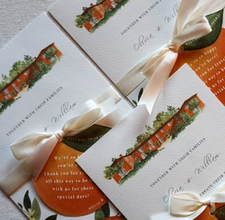 close up on invitation with orange cutout welcoming guests to the event white ribbon