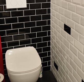 WC suspendu, revêtu avec faïences métro noire et blanches