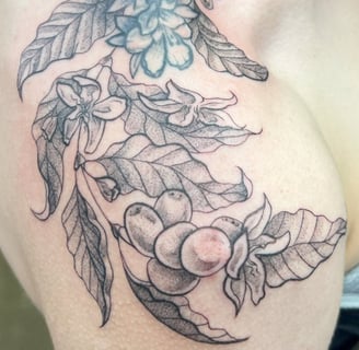 a woman with a tattoo on her chest and shoulder delicate leaf design