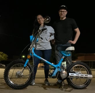 woman and man standing behind Honda scooter
