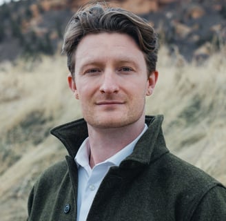 tristan lyons wearing a green jacket and a white shirt, looking directly at the camera