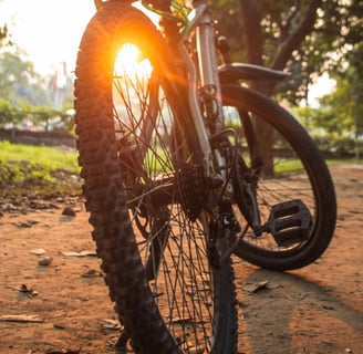 a bicycle parked on a dirt road in the sun