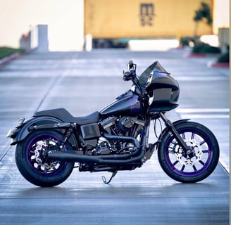black motorcycle with purple accents parked on a street