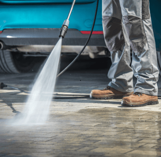 a man is using a pressurer to clean a driveway