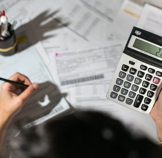 a person holding a calculator and a pen