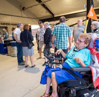 Person in a automatic wheelchair next to a small crowd of people