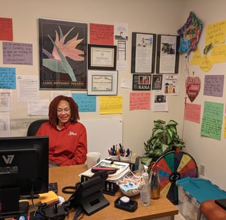 Felecia sitting at her office desk surrounded by sweet notes posted on the walls